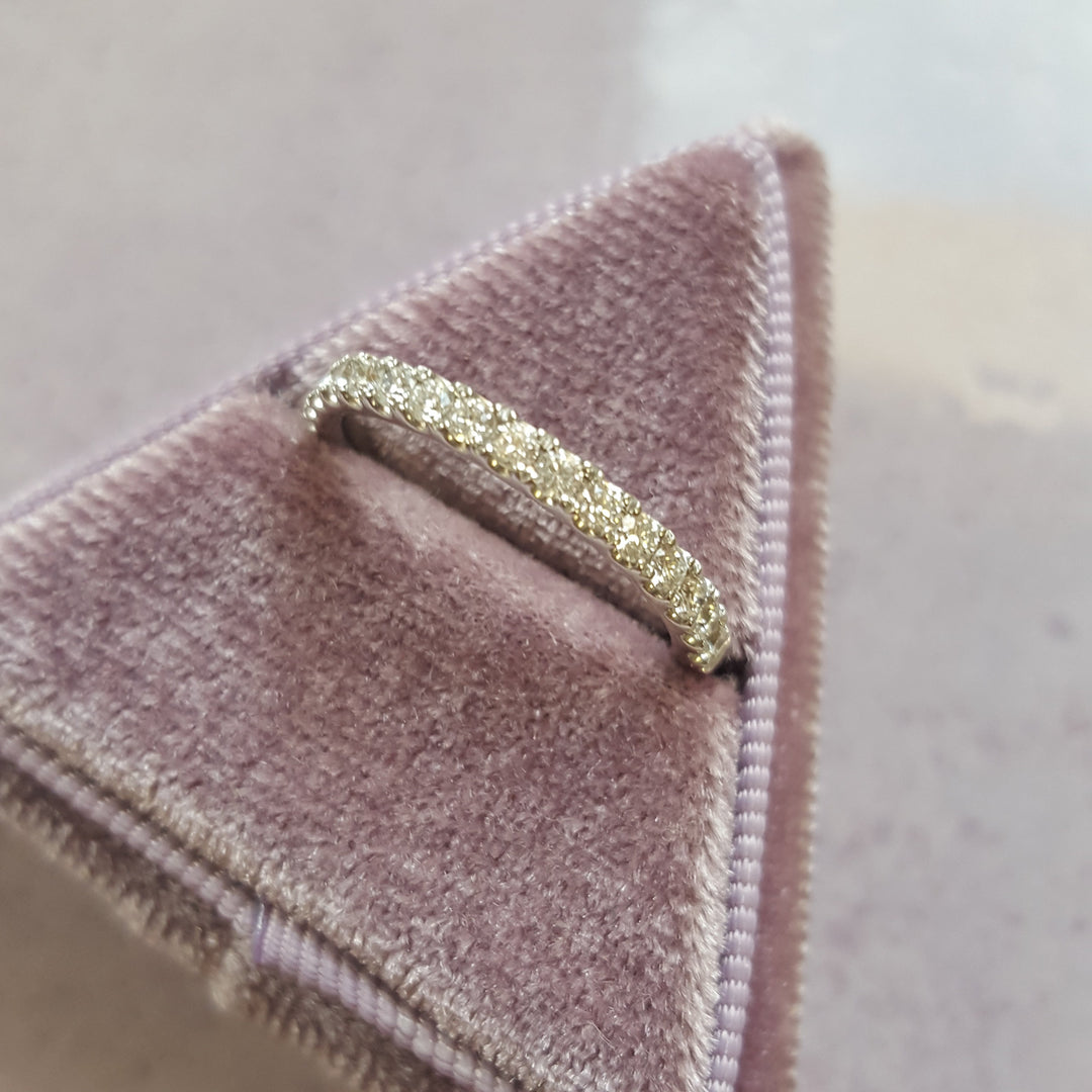Gold ring on a pink velvet cushion with a blurred background