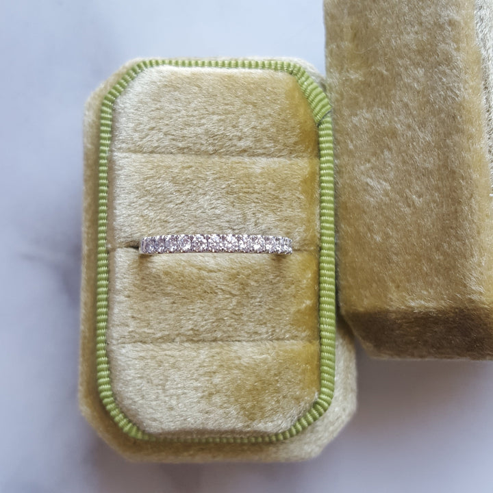 Diamond ring in a beige velvet box on a white background